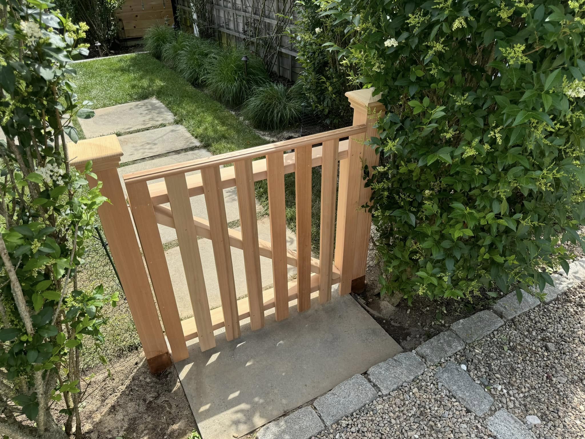 Custom cedar garden gate with stone walkway